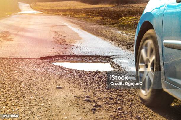 Car And Winter Pothole On Open Road Stock Photo - Download Image Now - Pot Hole, Sinkhole, Road