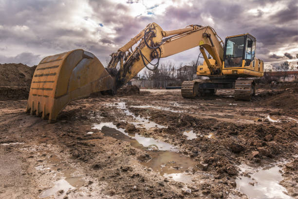 Excavator on a hard day of work on a construction site Heavy machinery for the construction wet photos stock pictures, royalty-free photos & images