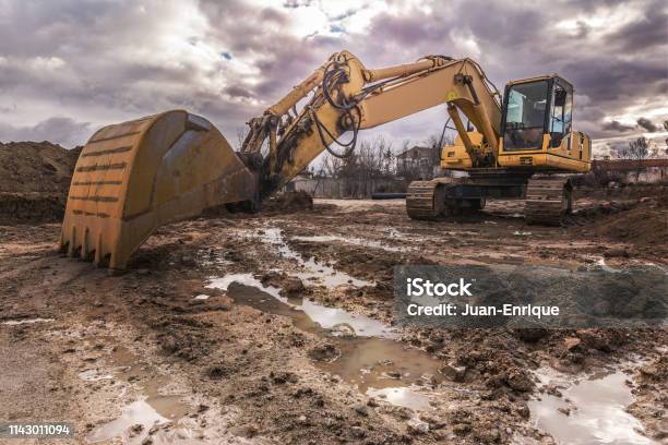Excavator On A Hard Day Of Work On A Construction Site Stock Photo - Download Image Now