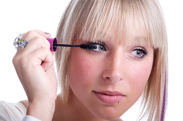 istock beautiful young woman applying mascara 114301225