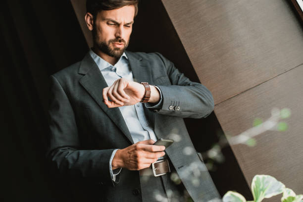 istock Concentrated businessman is checking time attentively outdoor 1143014172