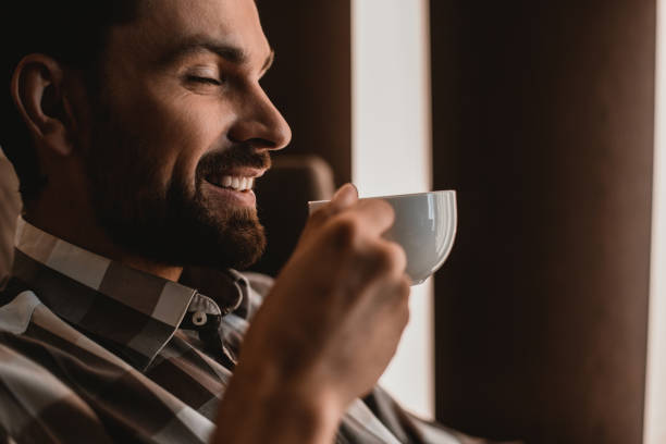 istock Happy guy is tasting coffee with delight 1143014188