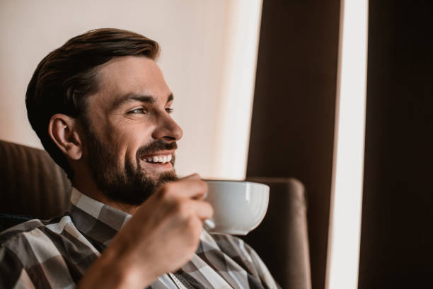 istock Cheerful man is enjoying his drink inside 1143014204