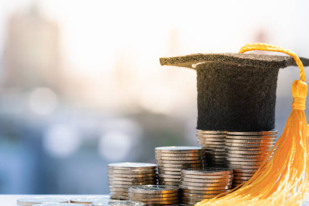 Graduation hat on top coin stack. Saving money for increase investment to student loan, education scholarship money background concepts. loans stock pictures, royalty-free photos & images