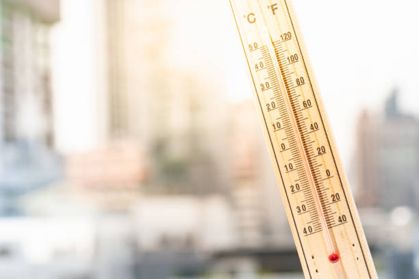 Thermometer against the city with hot weather background. Global warming, Heat Waves and Climate Change Concepts. competition heat stock pictures, royalty-free photos & images