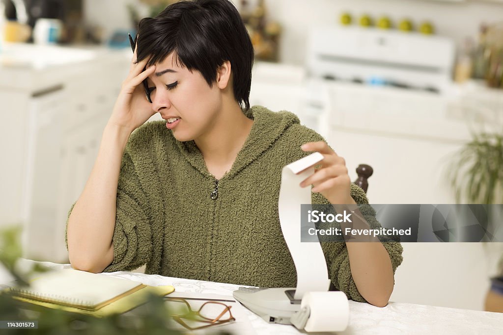 Mulher jovem de raça mista Agonizing sobre cálculos financeiros na cozinha - Royalty-free 20-29 Anos Foto de stock