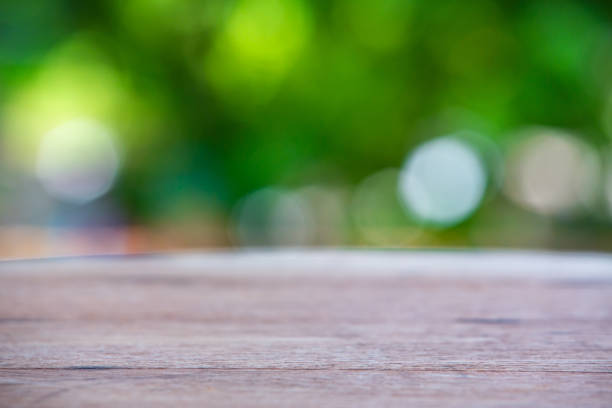 istock Empty curved wooden table texture, Green garden blurred bokeh background, Selective focus 1143016041