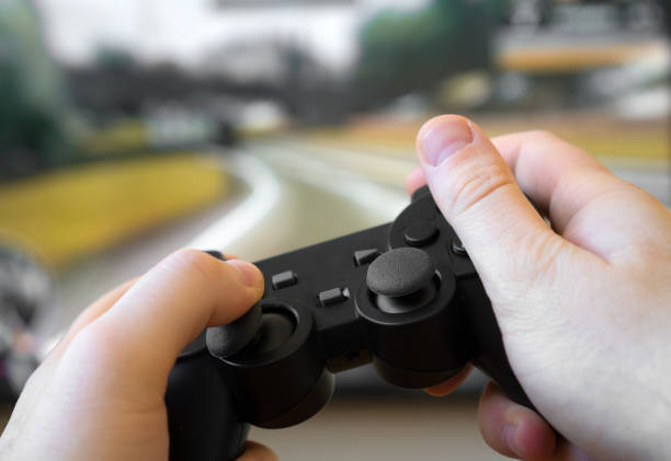istock Man playing racing video game on TV. Gamepad controller in hands. 1143016264