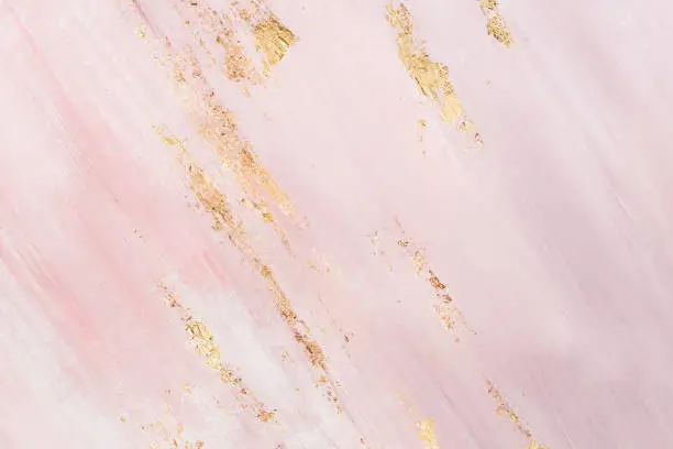 Photo of Delicate pink marble background with gold brushstrokes. Place for your design