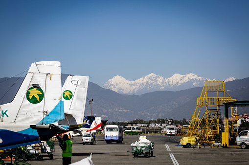View of the Kathmandu airport runway with planes and the snowy mountains of the Himalayas in the background,Kathmandu,Nepal