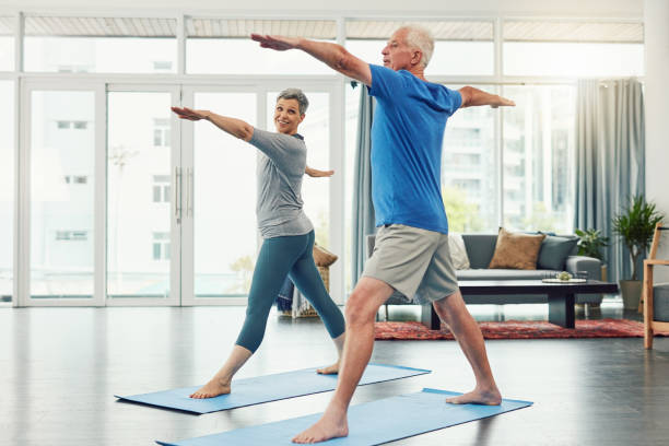 gemeinsam durch fitness und gesundheit - senior adult sport yoga exercising stock-fotos und bilder