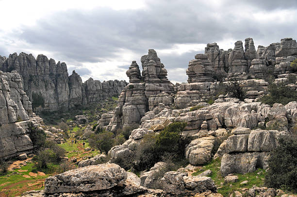 Tourists hiking in El Torcal El Torcal Nature Reserve with karst rock formations,located in the south of Antequera,Andalusia,Spain.  karst formation photos stock pictures, royalty-free photos & images