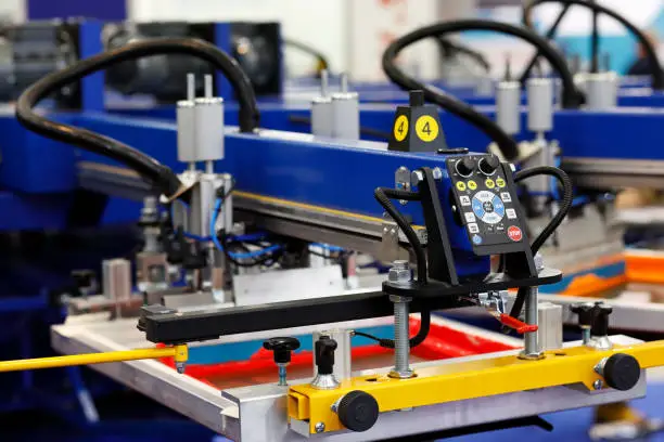 Automatic t-shirt screen printing rotary machine. Selective focus.