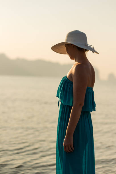 istock Woman standing on the beach at sunset 1143020159