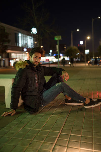 istock Stylish young man sitting on the floor 1143020580