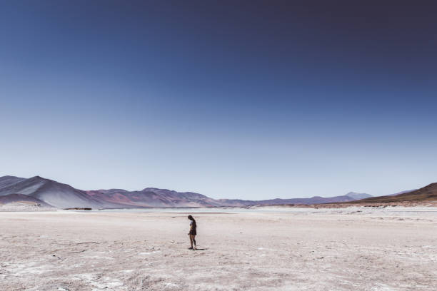 istock Woman walking at salt flat in Atacama desert 1143020678