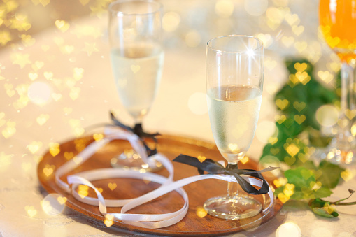 Two glasses with champagne for young couple at a wedding party with empty space for text.