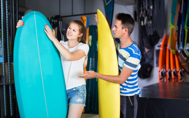 istock couple is demonstraiting surfboard in nautical shop. 1143022085