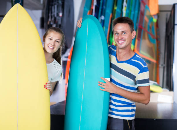 istock Couple demonstraiting new surfboard 1143022109