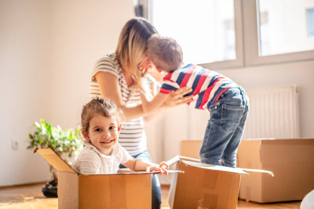 istock Happy siblings playing riding in box moving into new home 1143022296
