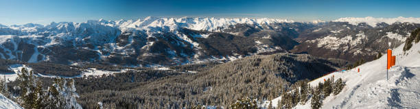 istock Panoramic view down snow covered valley in alpine mountain range with conifer pine trees 1143026205