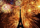 silhouette of eiffel tower illuminated at night by fireworks as holiday celebration