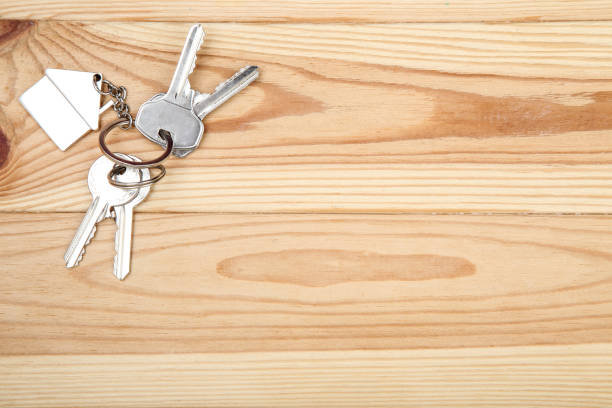 istock Silver keys with house symbol on brown wooden table 1143029509