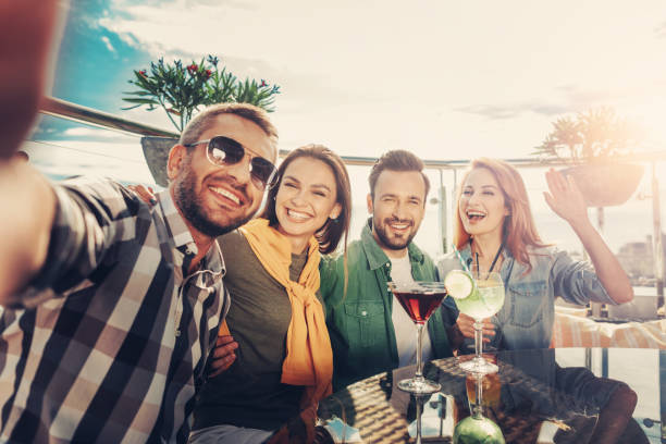 istock Two smiling couples making selfie at outdoor cafe 1143029657