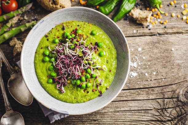 sopa cremosa de guisantes en el tazón - eating utensil green pea vegetarian food organic fotografías e imágenes de stock