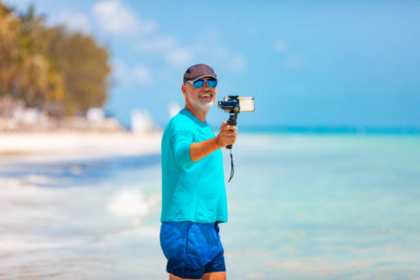 istock Senior Man Filming With Mobile Phone on Tropical Vacations 1143029868