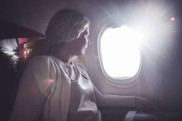 istock Female looking through airplane window. 1143031218