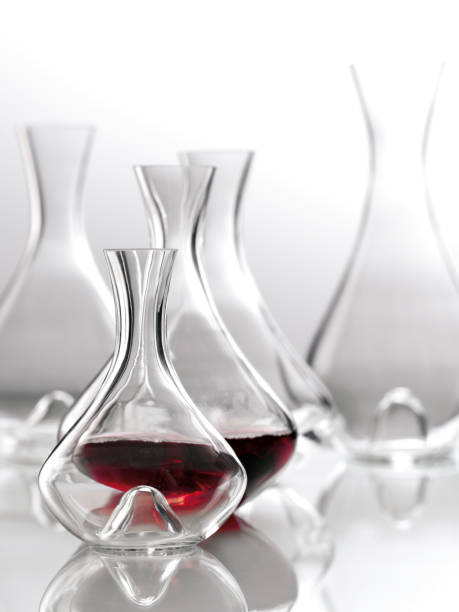 dekanter do vinho vermelho em uma tabela de vidro com os dekantrs de vidro vazios. - juice carafe glass decanter - fotografias e filmes do acervo