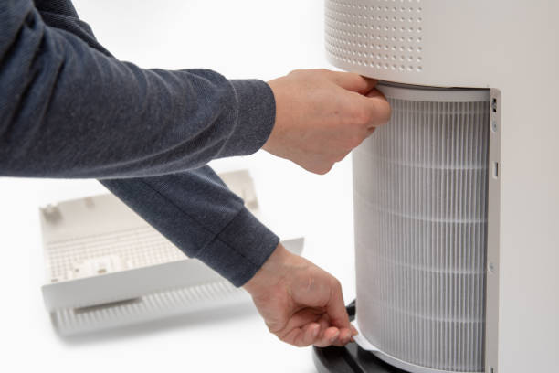 istock A man's hand turning an air purifier's filter into a new one. 1143034350