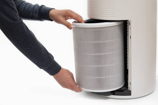 istock A man's hand turning an air purifier's filter into a new one. 1143034363