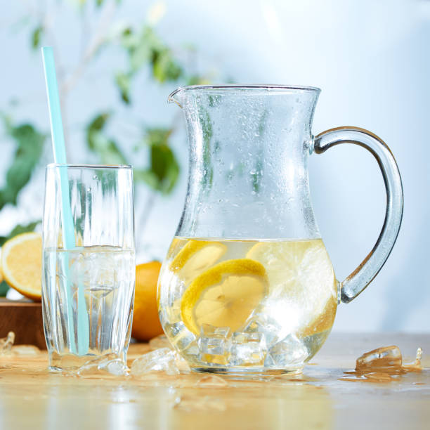 Infused water with cucumber, lemons and mint in a pitcher stock photo