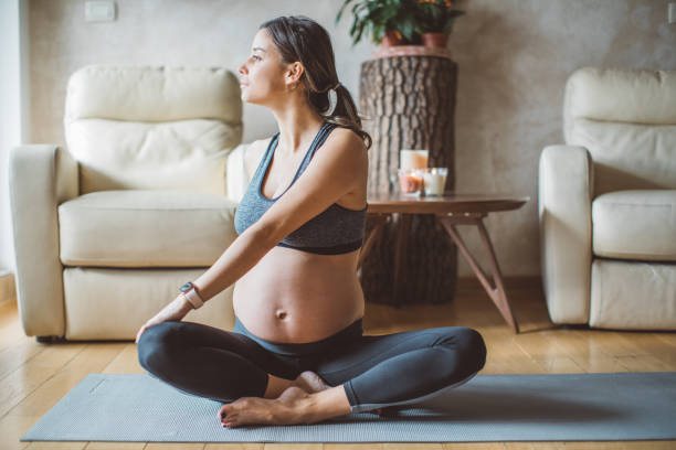 schwangere frau übt yoga - human pregnancy exercising relaxation exercise sport stock-fotos und bilder