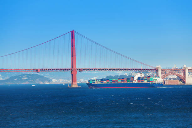 Full loaded cargo ship passing under Golden Gate Bridge at the port of San Francisco, USA