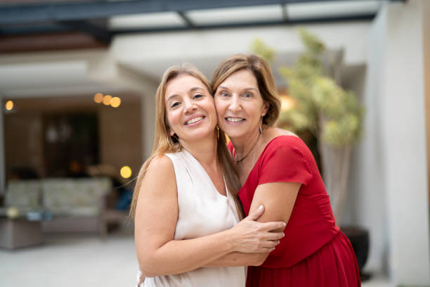 istock Mother and daughter embracing in front o house 1143043629