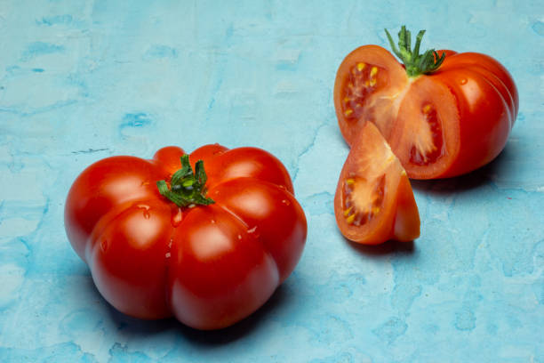 istock Brandywine red tomatoes on grunge blue background 1143044554