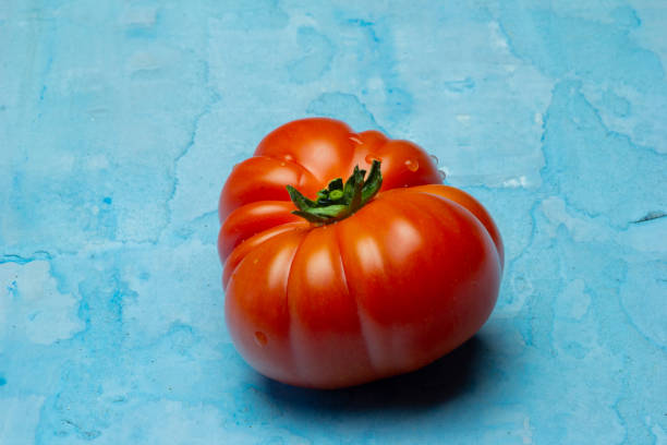 istock Brandywine red tomatoes on grunge blue background 1143044558