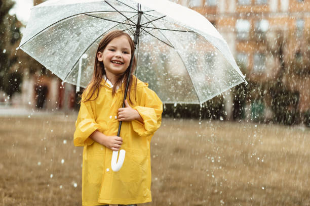 istock Joyful girl playing outside in rain 1143045677