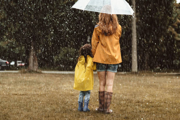 istock Mother and daughter enjoying rain 1143045693