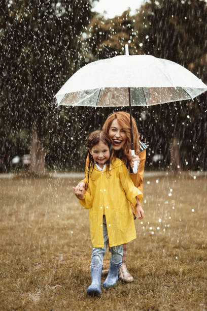 istock Mom and daughter hiding from rain 1143045695