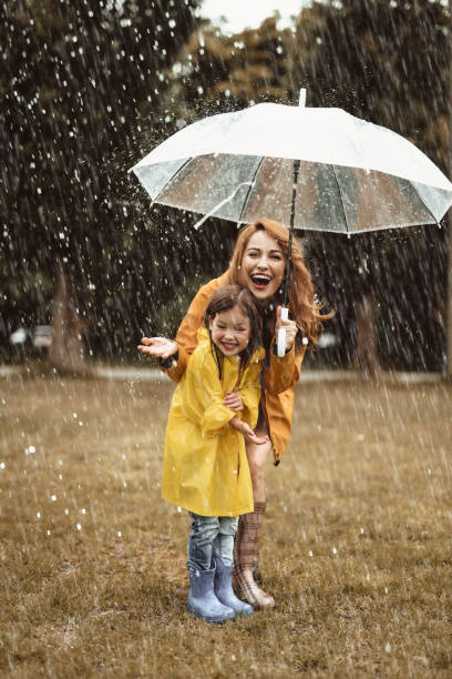 istock Delighted mom and kid enjoying rain 1143045697