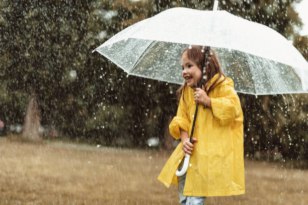 istock Delighted little girl hiding from rain 1143045701