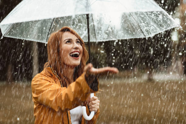 istock Excited woman catching rain drops outside 1143045703