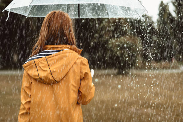 female walking during rain outside - rain women umbrella parasol imagens e fotografias de stock