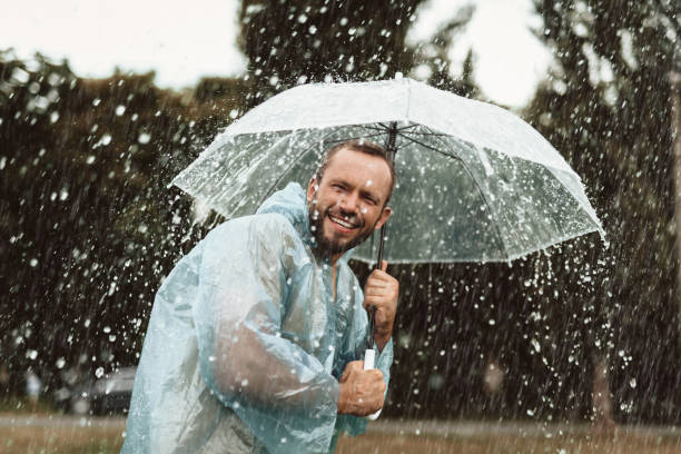 istock Positive male hiding from rain outside 1143045745