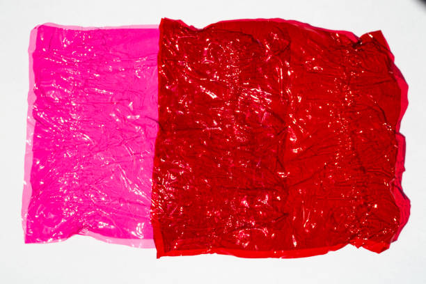Thin sheet of multi coloured cellophane with shiny crumpled surface texture on white background, Abstract, Light & Shadow concept