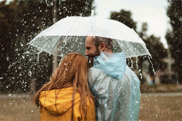 istock Happy couple strolling in rainy weather 1143045786